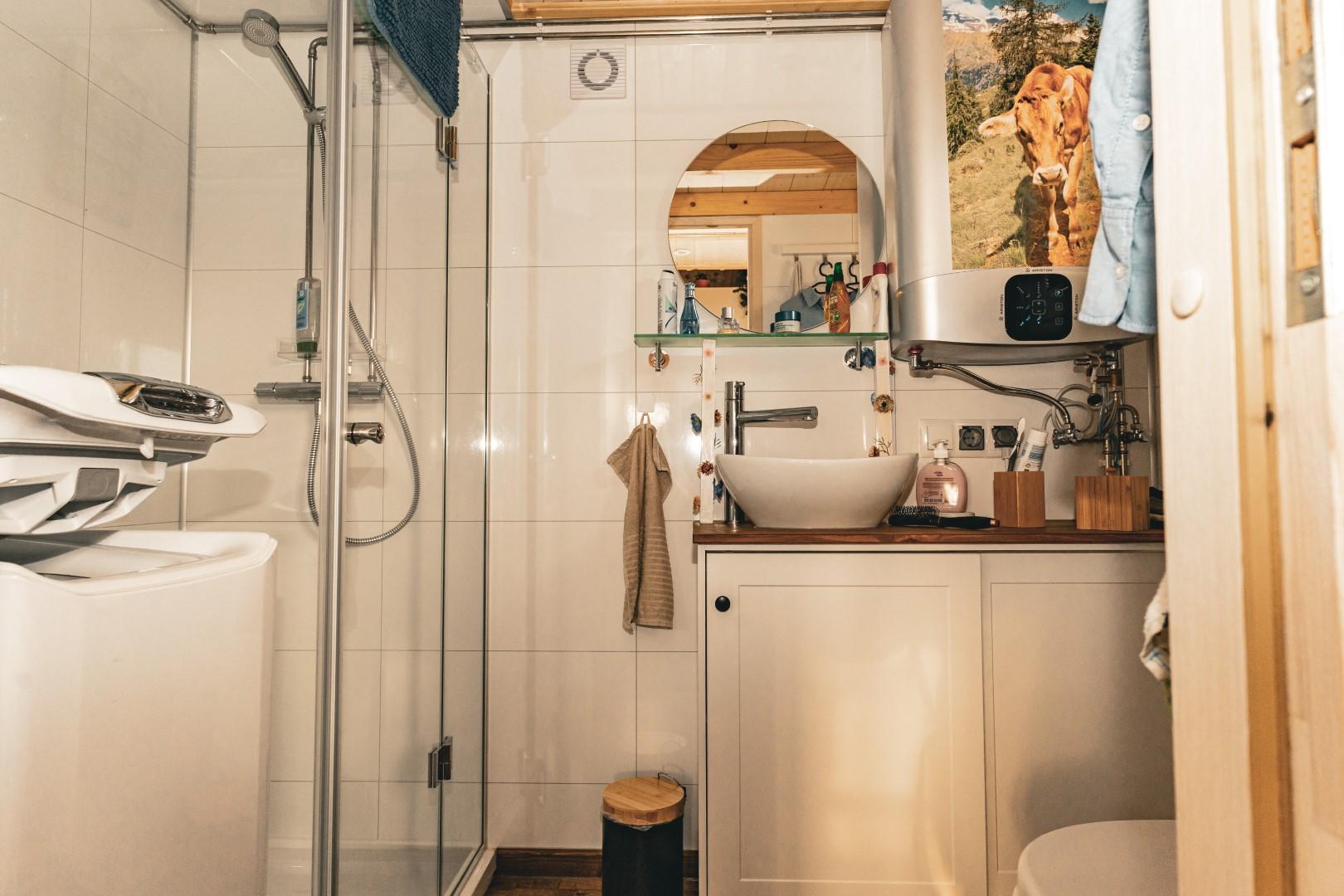 Bad mit Dusche, WC und Toplader-Waschmaschine (li.)