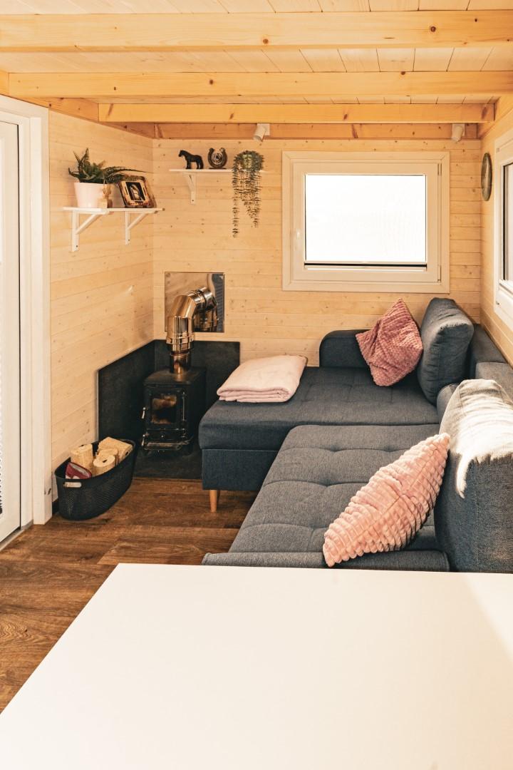 Die Couch ist gleich das Erste, worauf man blickt, wenn man zur Tür (li.) hereinkommt. Daneben das Lieblingsstück von Elke Schneider in ihrem Tinyhouse: der Ofen