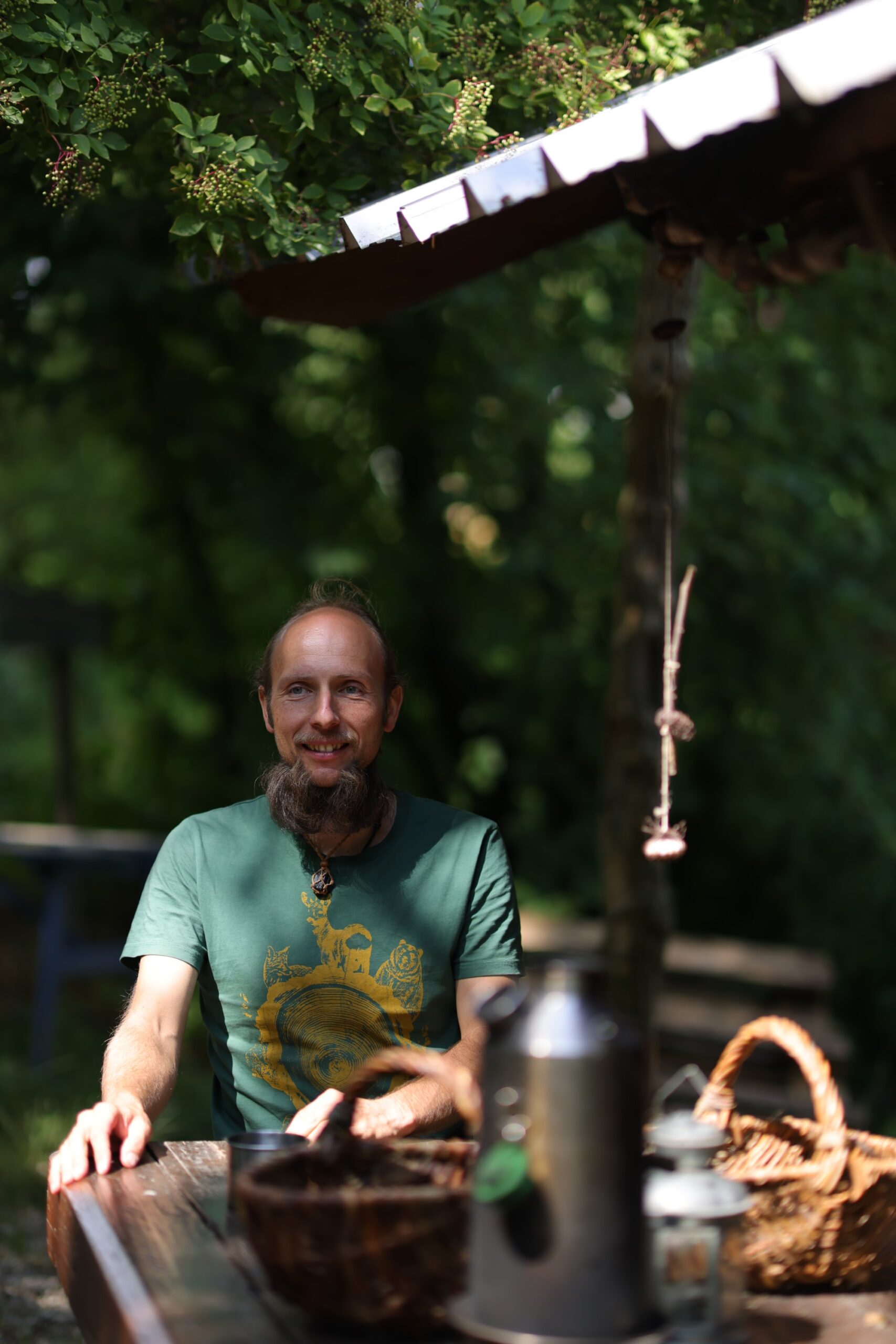 Christian Rachl auf der A.p.e. Ilminsel. Hier gibt es ein Tipi-Zelt, eine Schlaf-Hütte, eine Feuerstelle mit Sitzmöglichkeiten in der Natur und vieles mehr zu entdecken. Christian zeigt, wie man Feuer und anschließend Tee aus Fichten und Brennnesseln macht.